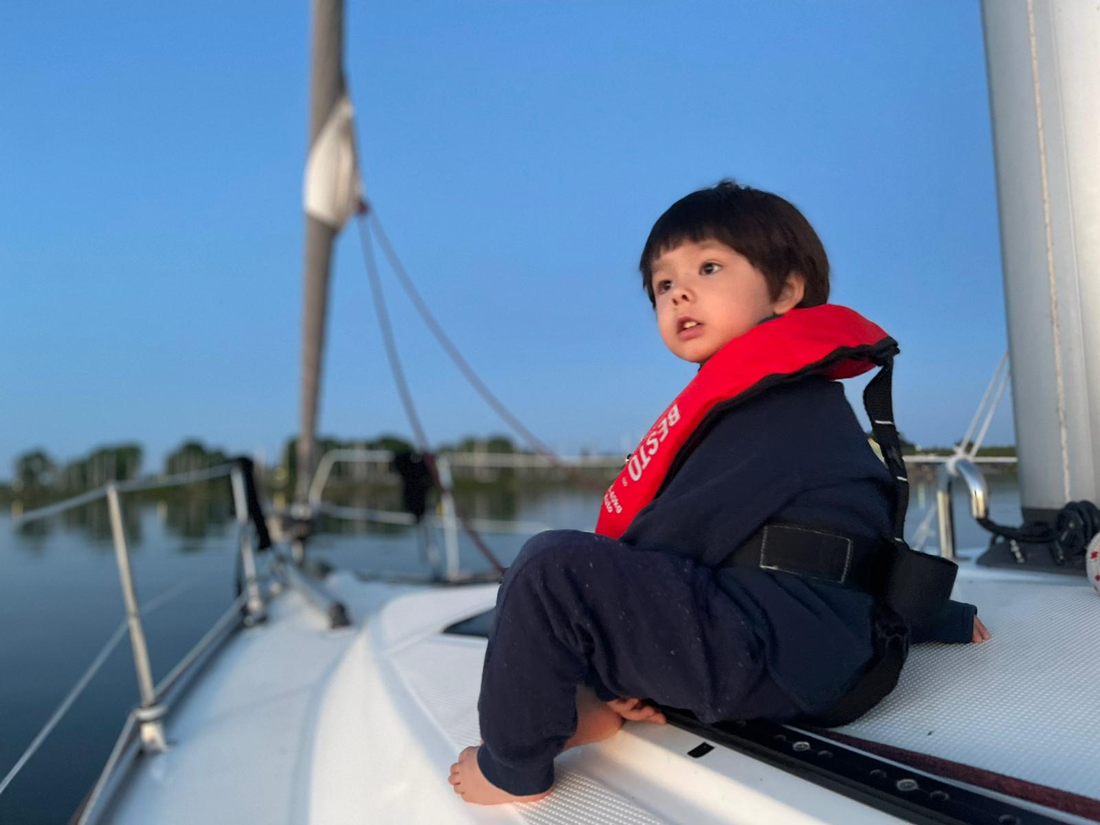 A young crew member sitting quietly on deck at anchorage